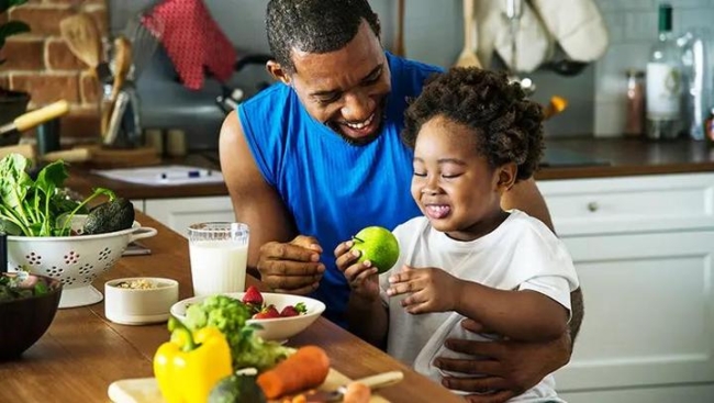 Father holding child on his lap at a counter