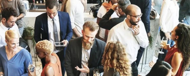 Group of people talking, holding champagne glasses