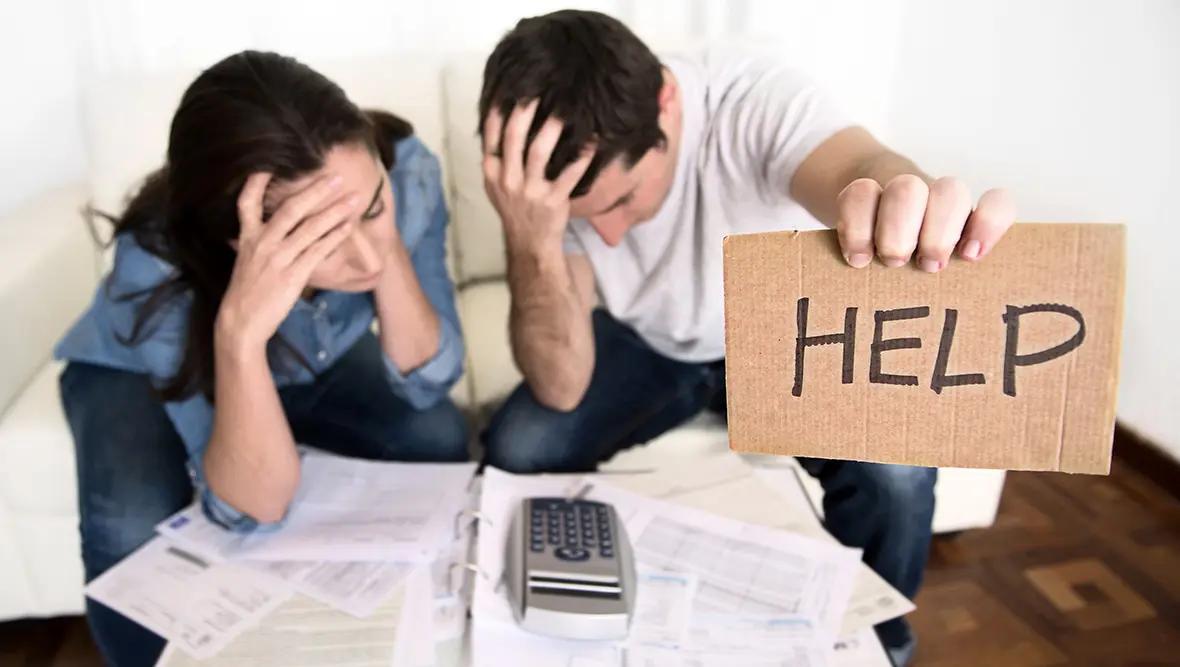 Couple holding sign for Help