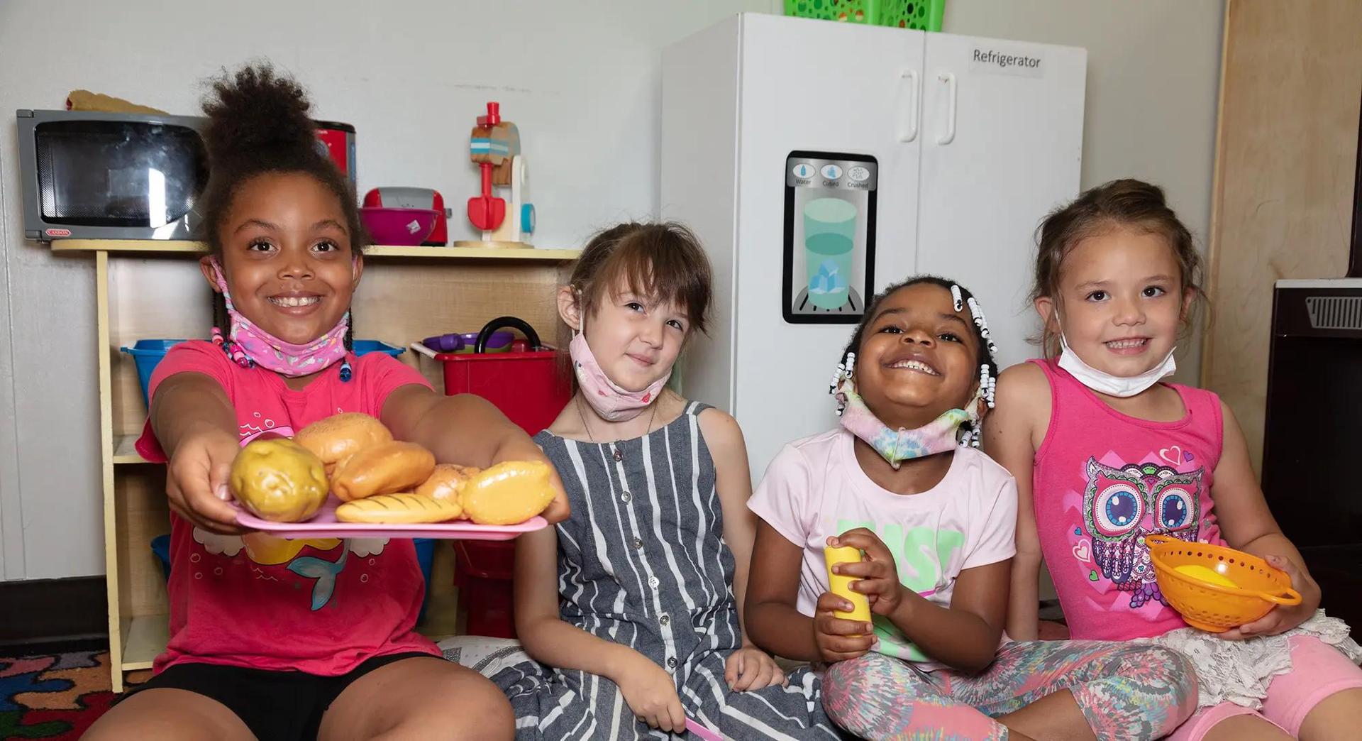 Four kids sitting and smiling at camera