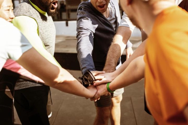 People in a circle with their hands stacked