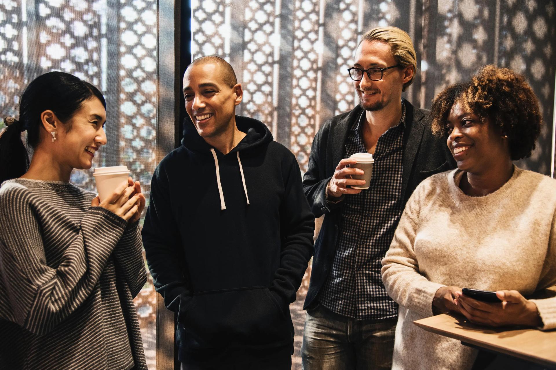 Group of people talking, holding coffee cups