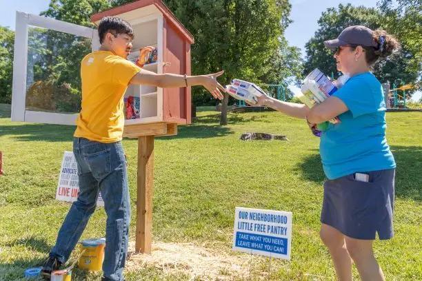 Two volunteers stocking a free pantry