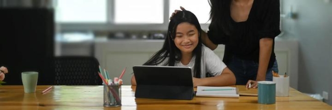 Girl seated at a table with a laptop