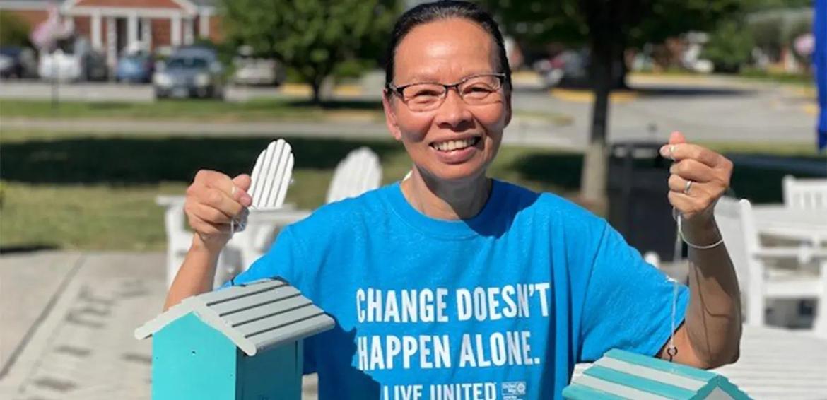 Volunteer holding bird houses